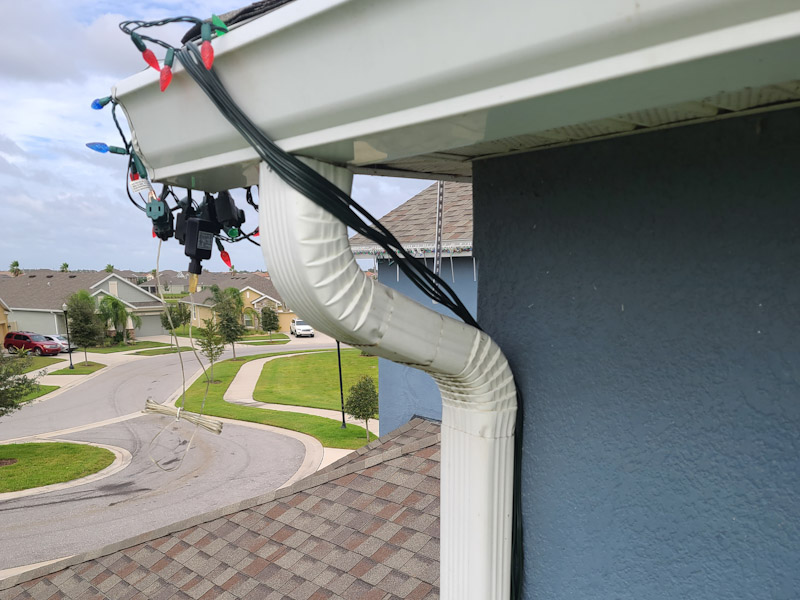 extension cords behind a gutter to make christmas lights look more professional